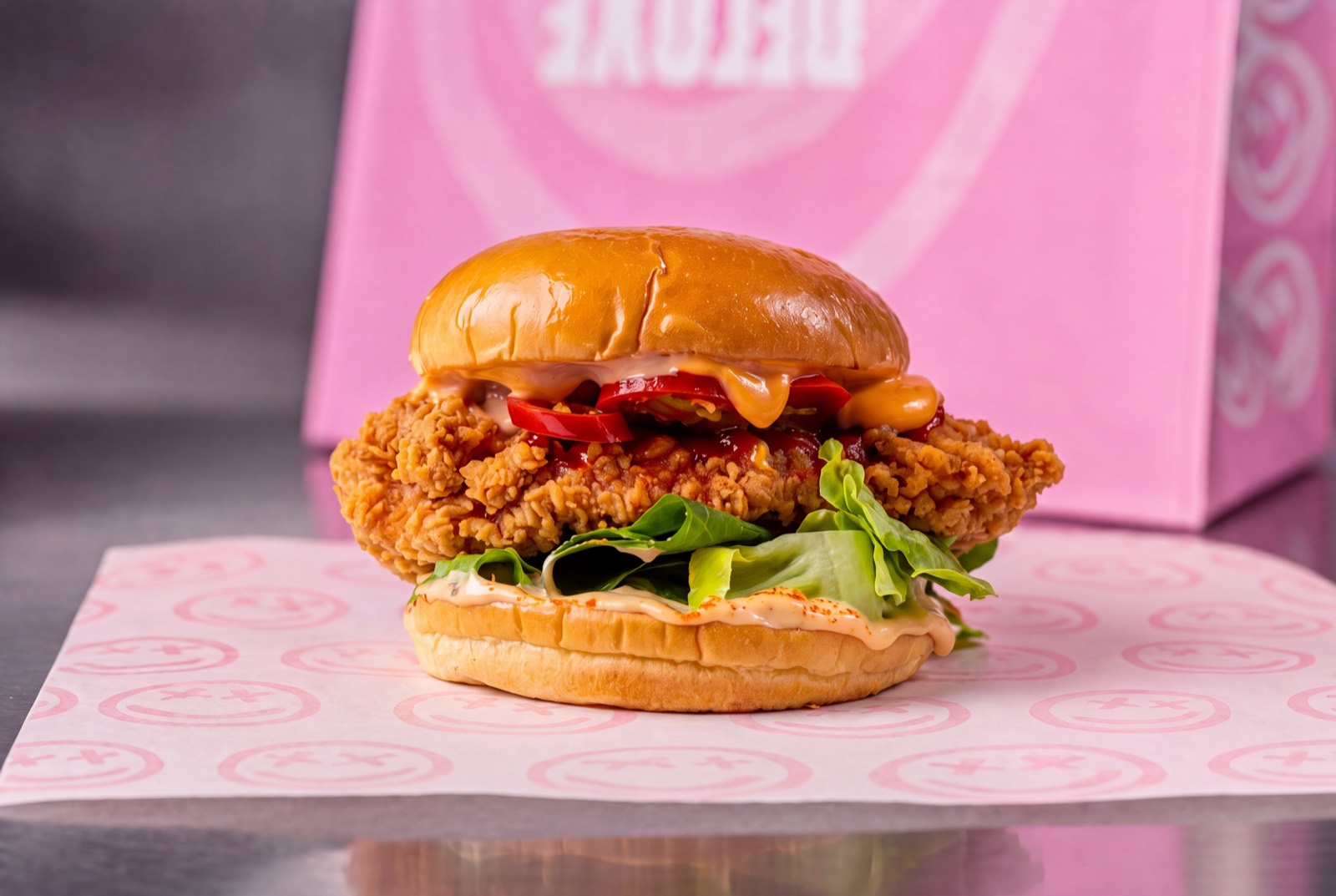 Buttermilk brined crispy chicken burger with red peppers, lettuce and house sauce.