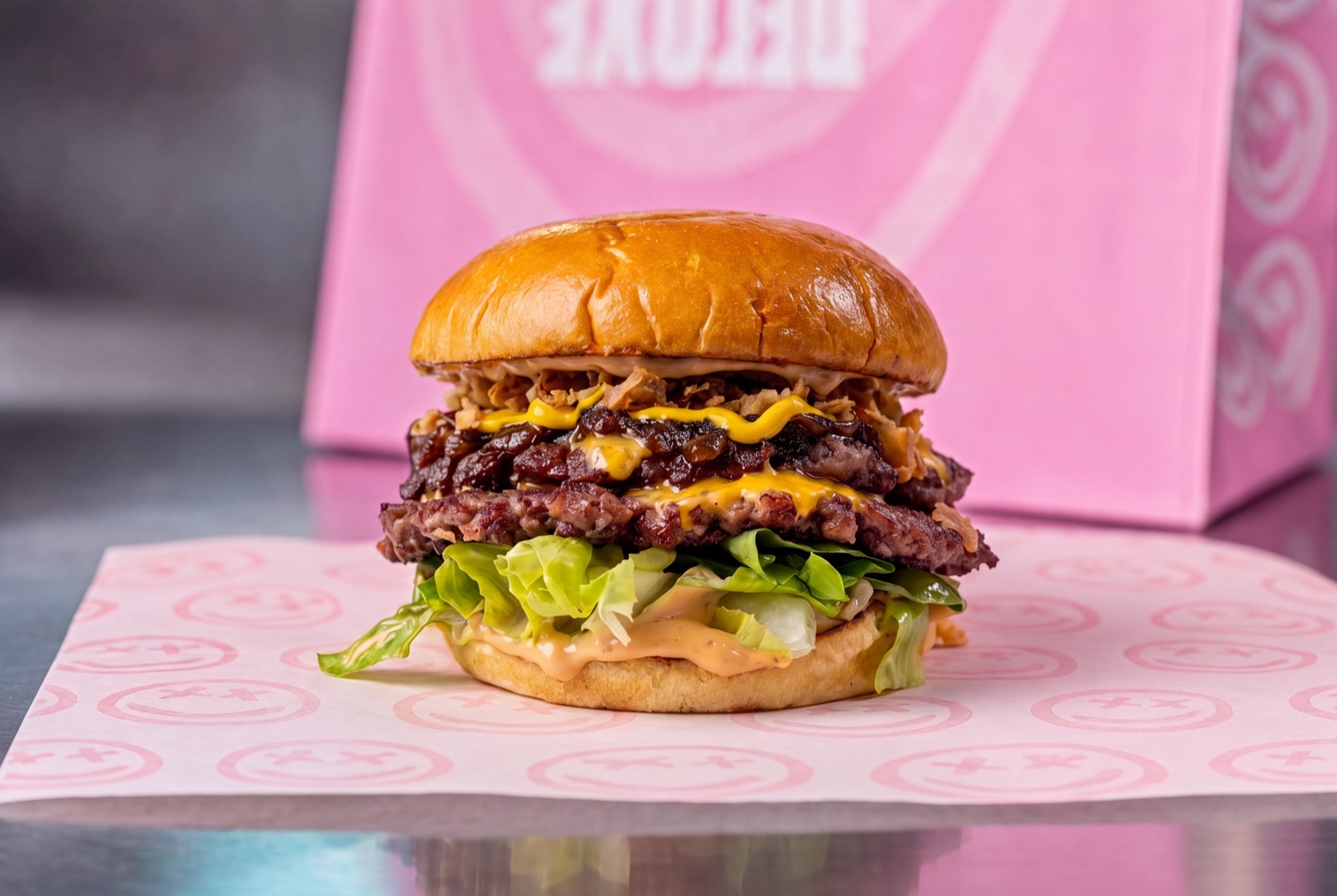 Double smashed beef burger with cheese, burnt ends, crispy onions and mustard.